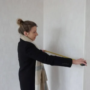 Réalisation d'une mesure sur le mur d'un appartement